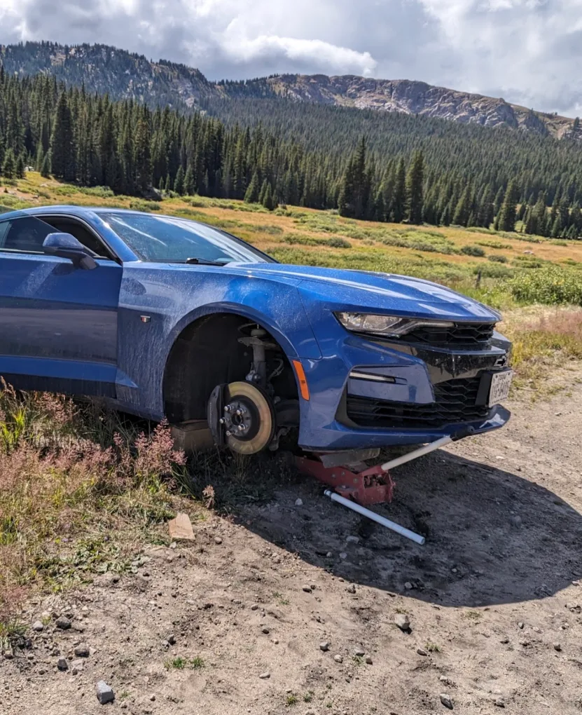 Vehicle receiving service outdoors near a mountain road